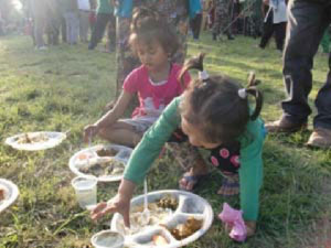 Two Girls Sitting on the Floor With a Plate of Food